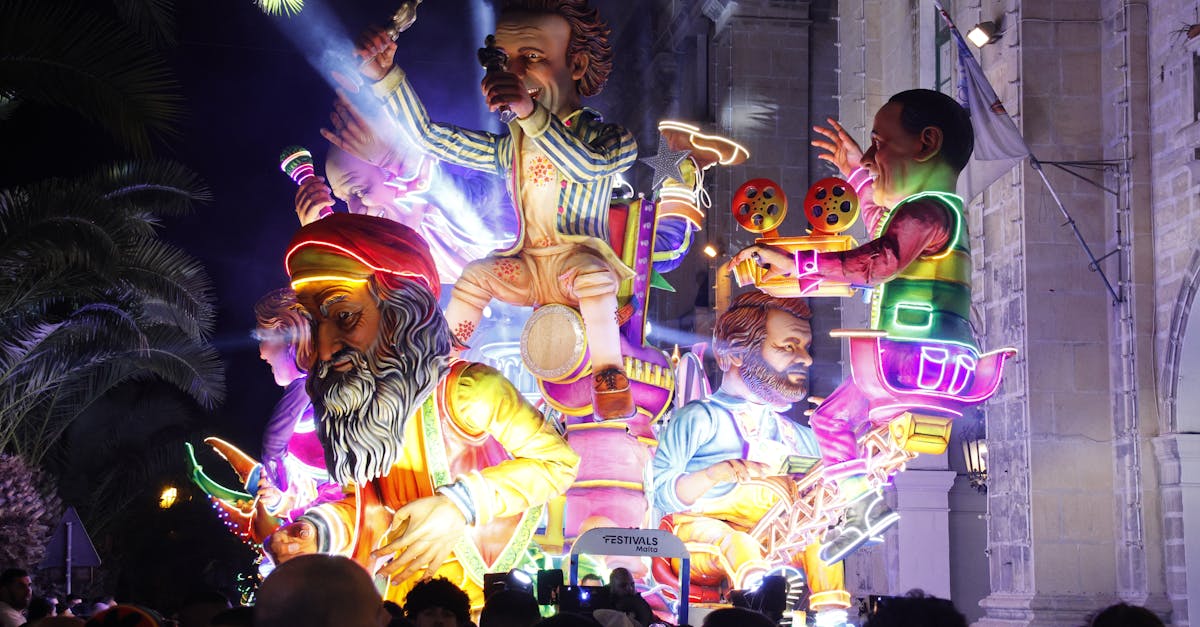 Colorful illuminated float at a nighttime festival with large whimsical figures.