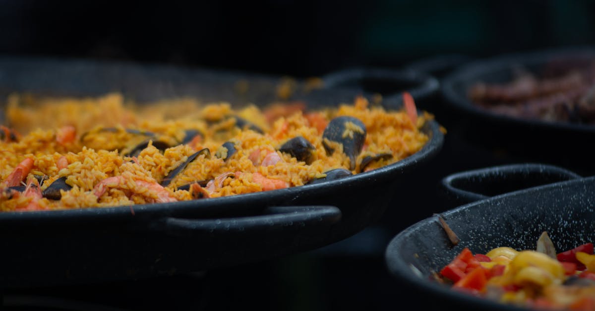 Appetizing close-up of traditional seafood paella cooking in a large outdoor pan.