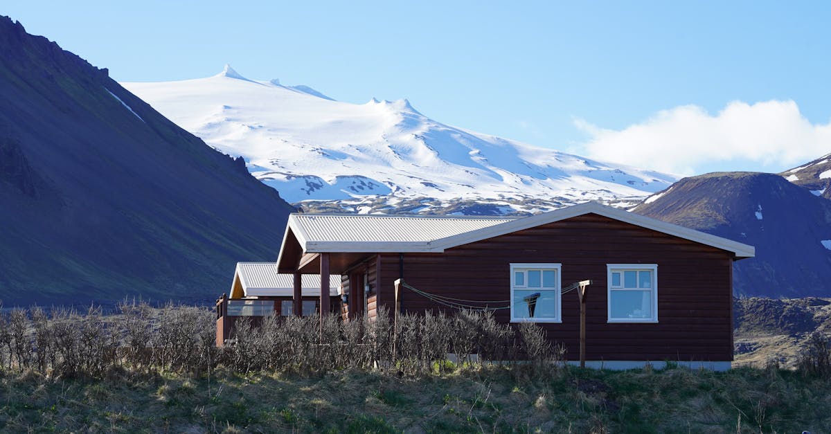 Cozy wooden cabin set against the dramatic Icelandic mountains and glaciers.