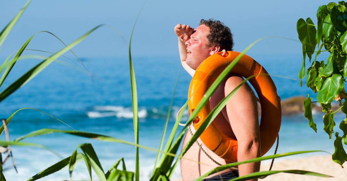 A man with a lifebuoy enjoys a sunny day at the beautiful tropical beach of Unawatuna, Sri Lanka.
