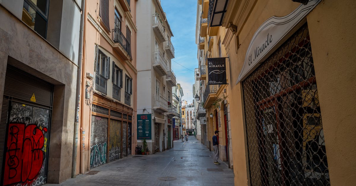 Explore a quaint alleyway in Valencia's historic quarter, revealing its urban charm and vibrant street art.