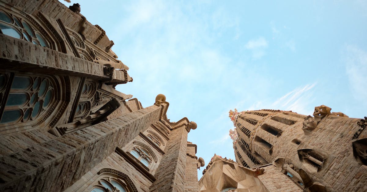 Upward view of Sagrada Familia towers in Barcelona with clear blue sky.