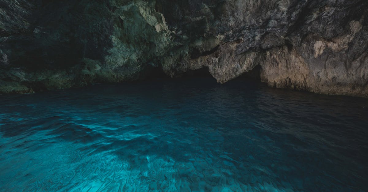 Calm blue water inside a mysterious cave, illuminated by natural light.