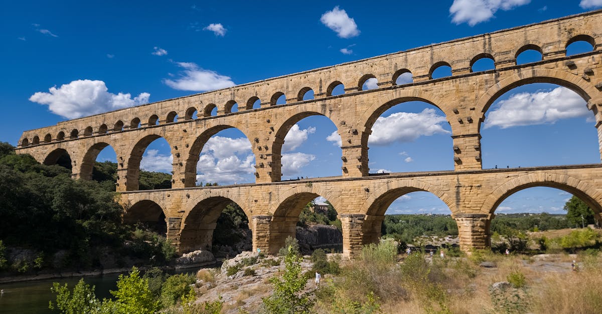 The Pont du Gard aqueduct, a Roman architectural marvel, against a clear blue sky in Nîmes, France.