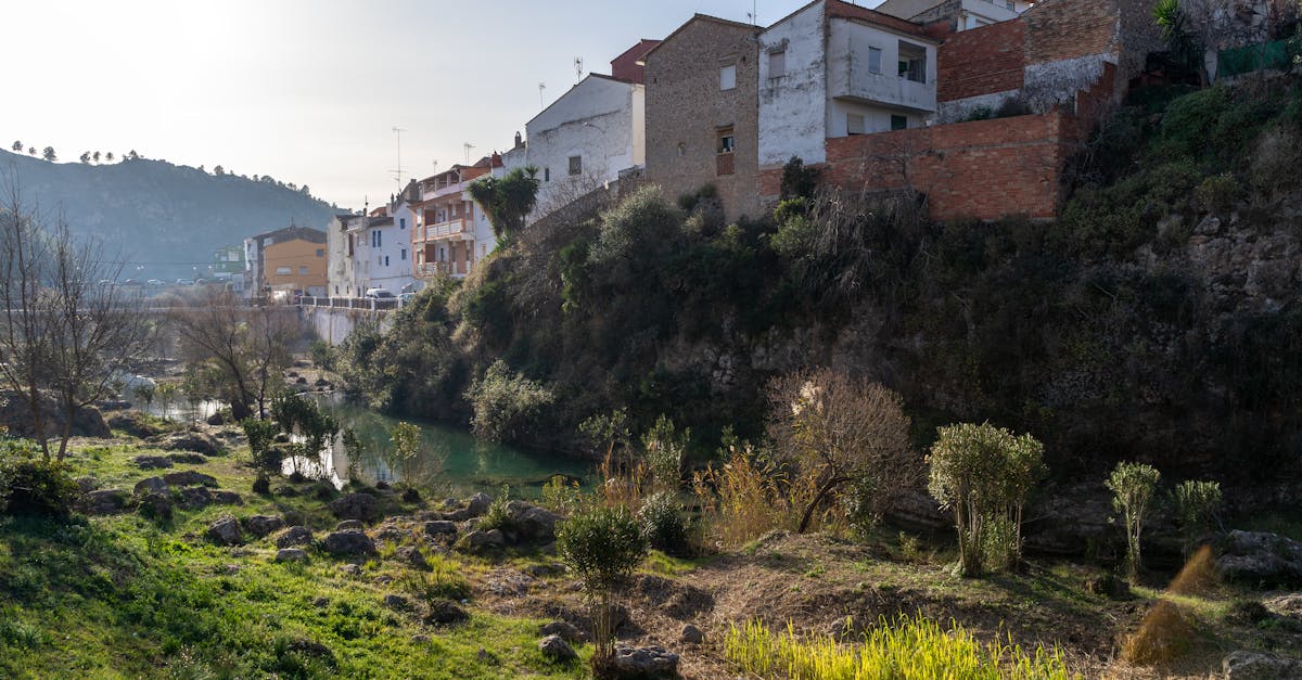 Picturesque landscape of Bolbaite, Spain with houses along the riverbank and lush greenery.