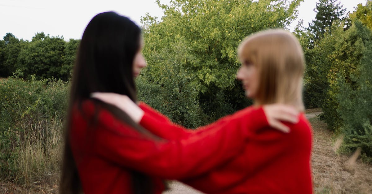 Two women embracing in a blurred photo outdoors, capturing a moment of friendship.