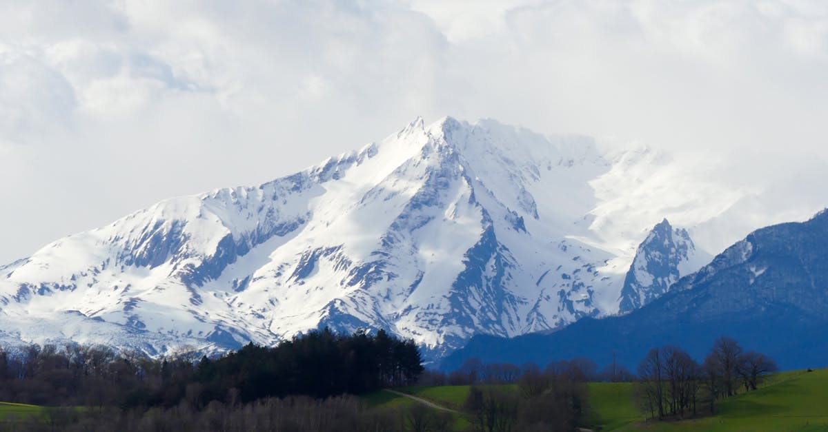 Spectacular view of a snow-capped mountain in the French Alps under a cloudy sky.