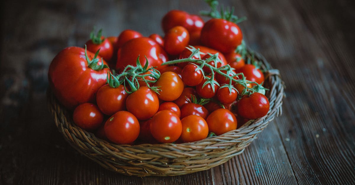 Vibrant basket of fresh red tomatoes on a rustic wooden table, perfect for healthy food concepts.