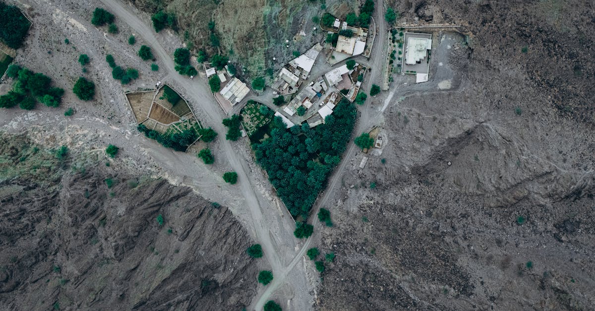 Stunning aerial view of a village and oasis amidst rugged mountain terrain in Nizwa, Oman.