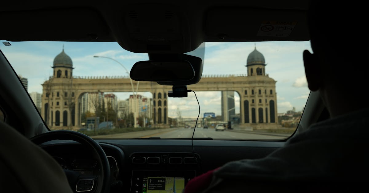View from car interior of a grand archway in the distance during drive.