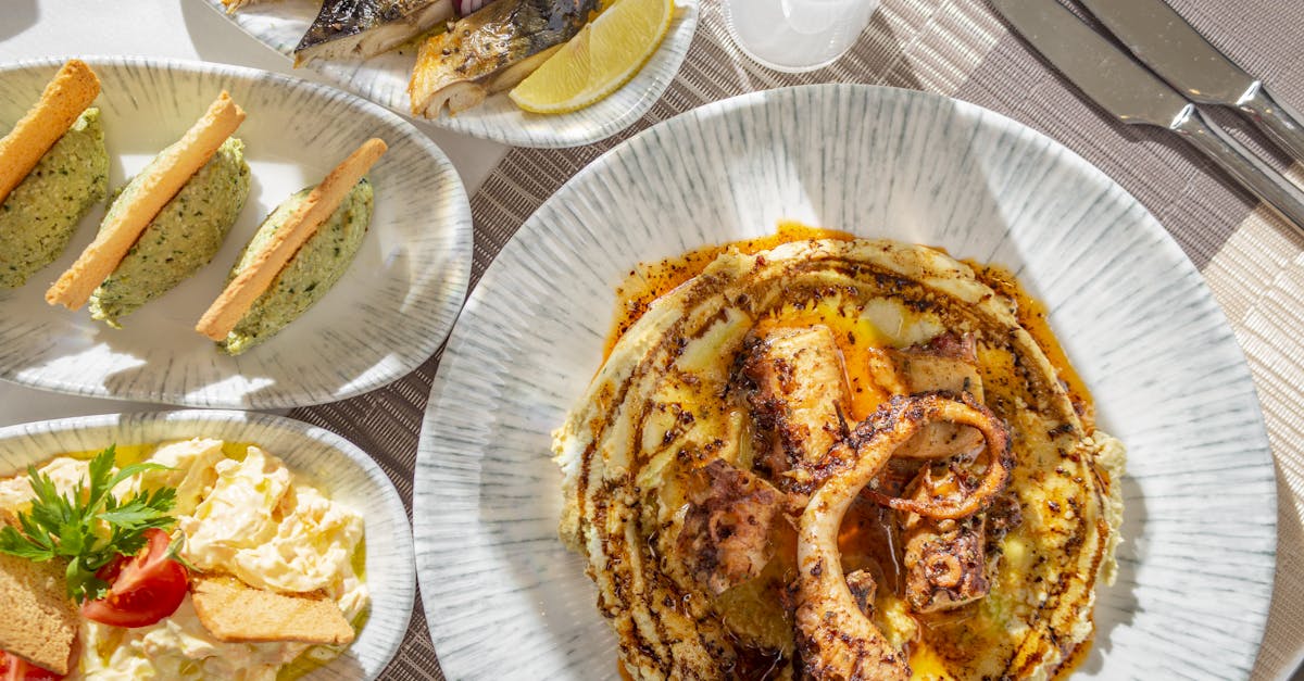 Delicious fine dining seafood platter featuring grilled octopus and fresh sides served on elegant tableware.