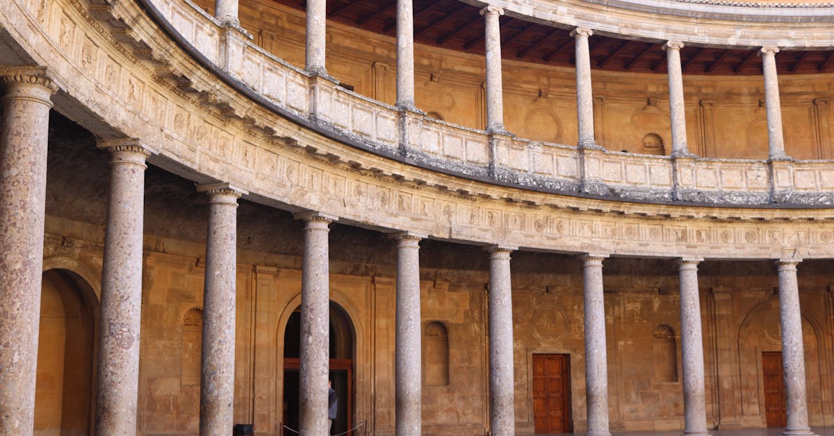 Explore the Renaissance architecture of the circular courtyard at Charles V Palace in Granada, Spain.