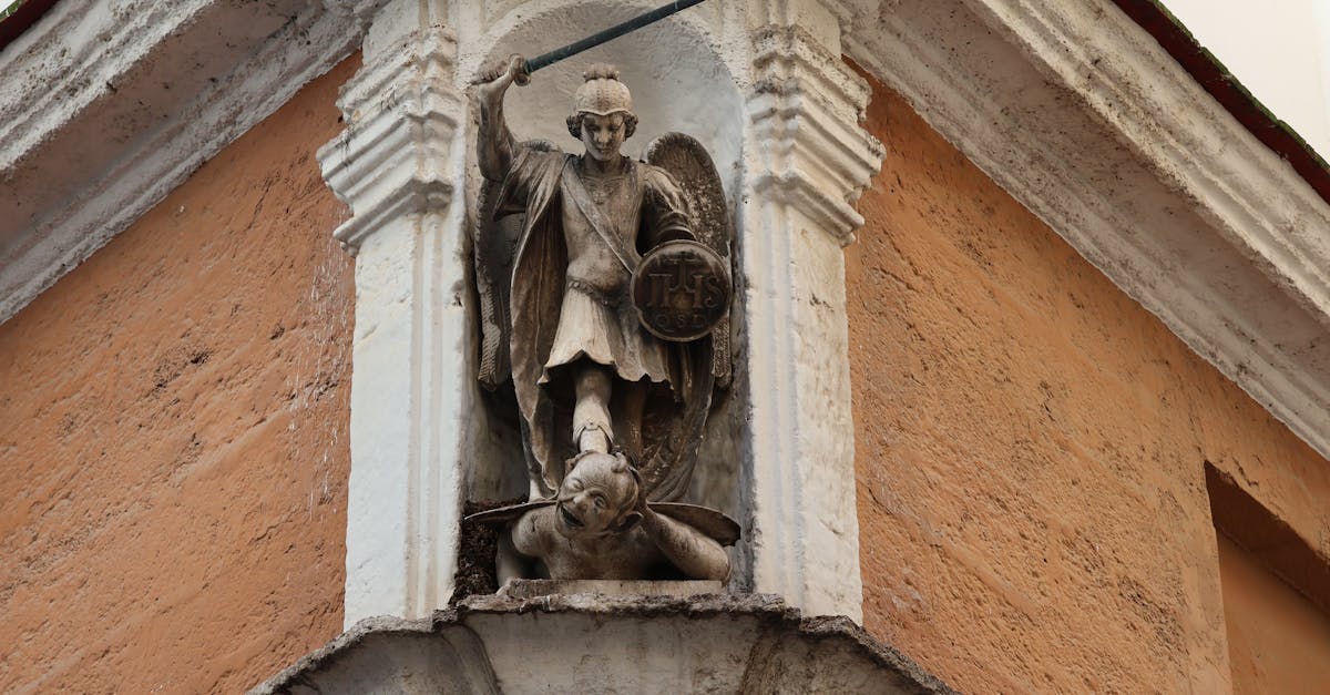 Detailed view of St. Michael Archangel statue on a historic building in Cádiz, Spain.