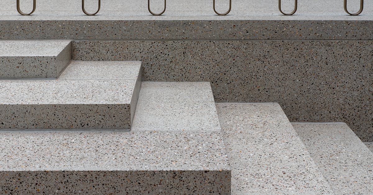 Minimalist concrete staircase featuring terrazzo texture and sleek metal railings.