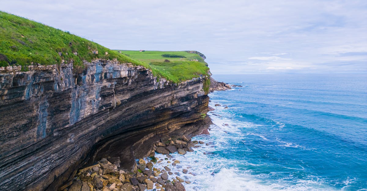 Breathtaking aerial view of the rugged coastline in Galicia, Spain, with dramatic cliffs and vibrant blue waters.