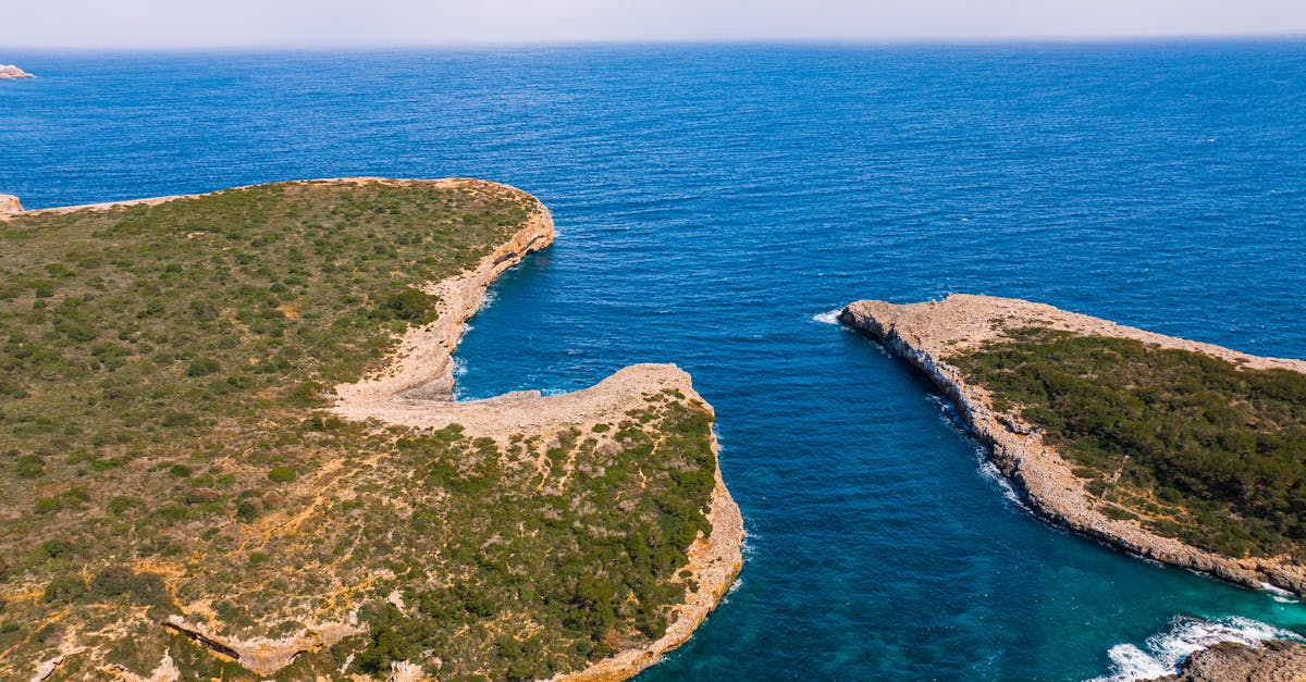 A stunning aerial view of Mallorca's rugged coastline with turquoise waters and lush green cliffs.