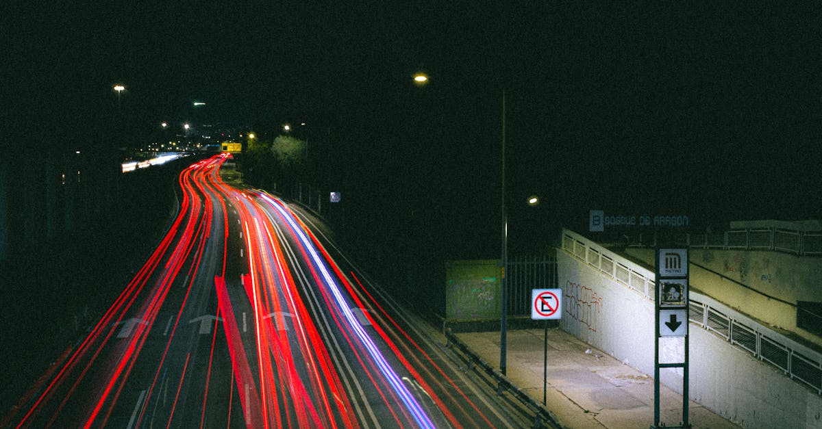 Dramatic long exposure of vibrant traffic lights on a city highway at night.
