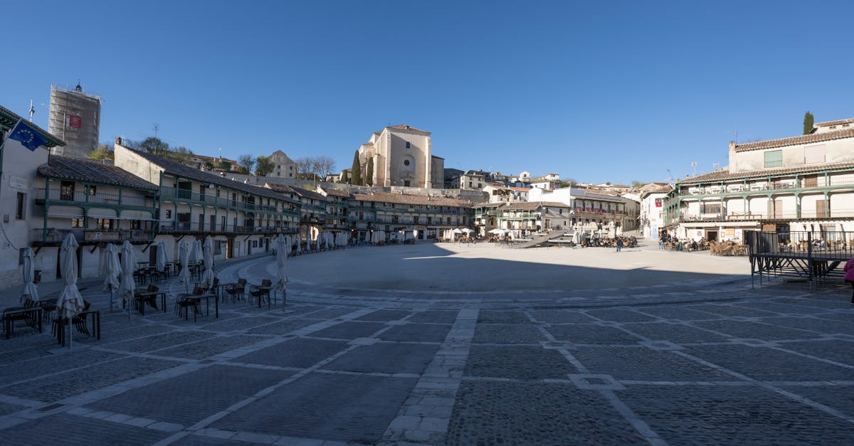 Wide view of Chinchón's historic Plaza Mayor, showcasing its distinctive architecture under a clear blue sky.