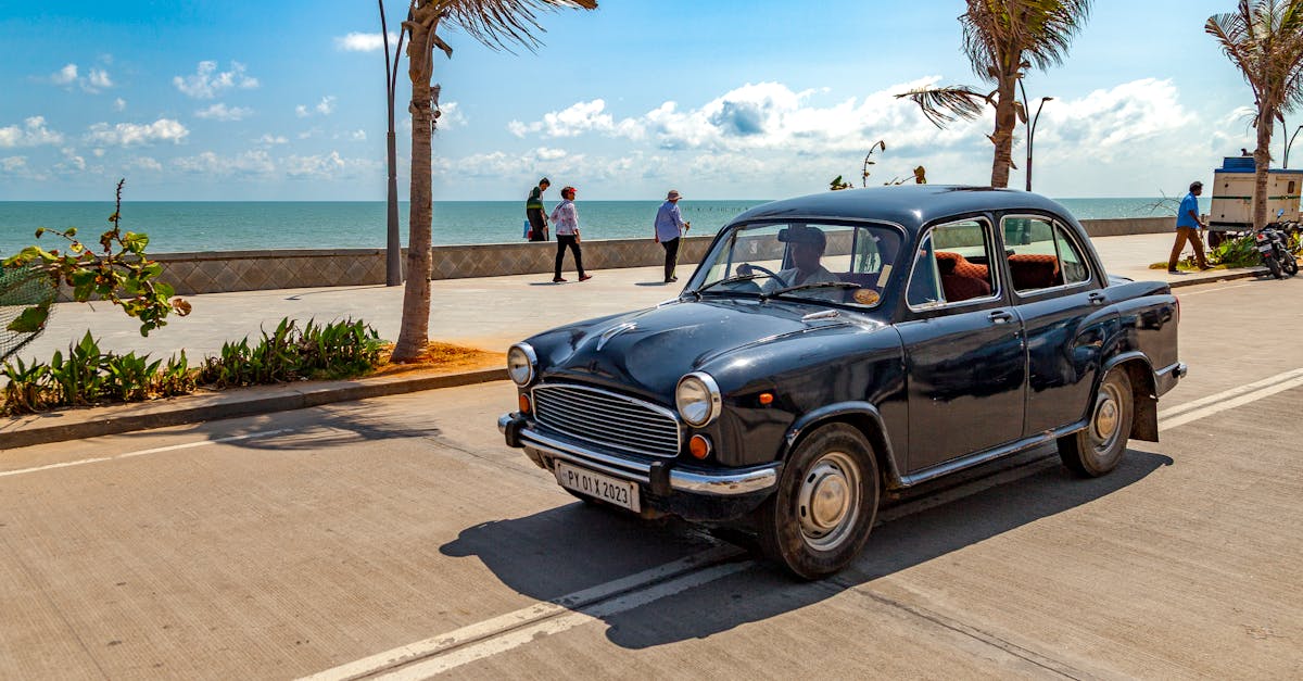 Vintage car cruising down scenic Mahabalipuram coastline, capturing a blend of old charm and natural beauty.