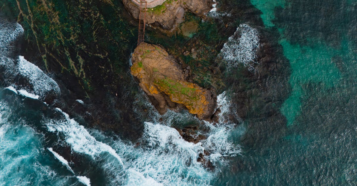 A stunning aerial shot of a rocky coastline and crashing ocean waves. Vibrant and dramatic seascape.