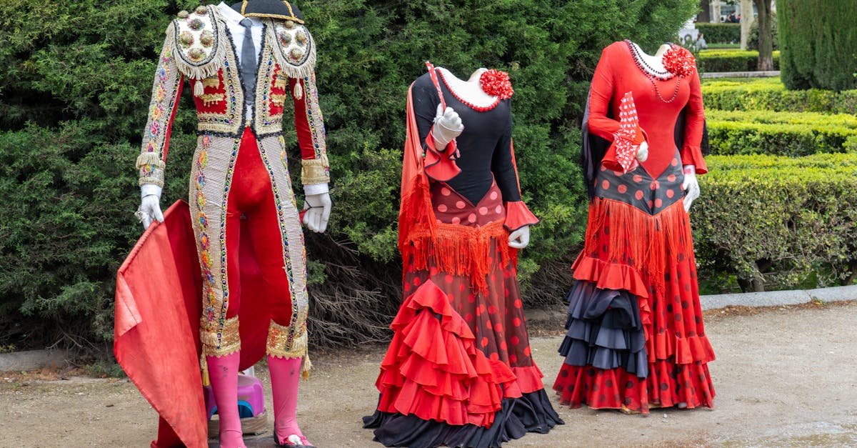 Traditional flamenco dresses and a bullfighting suit displayed outdoors in Madrid.