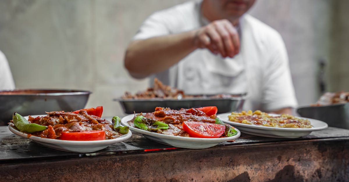 Chef prepares traditional Turkish kebab with fresh tomatoes and peppers on an outdoor grill in Bursa.