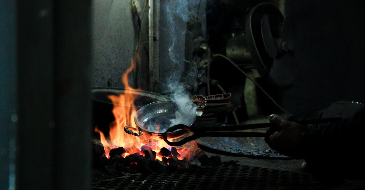 A blacksmith uses tongs in an Ankara workshop while heating metal over an open flame.