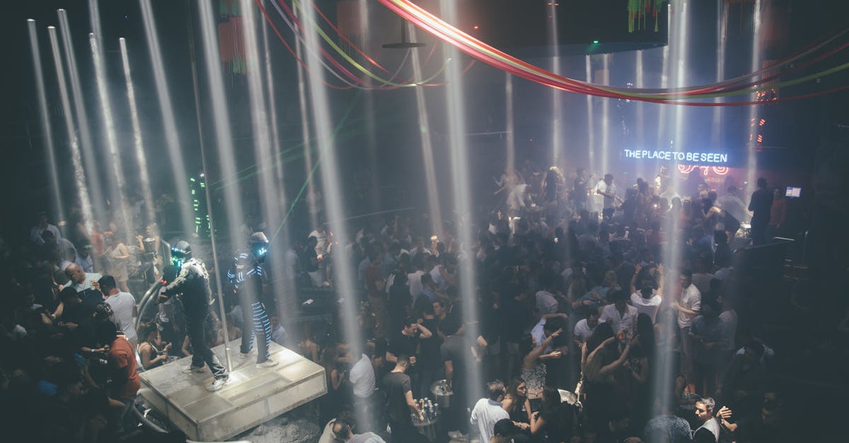 Energetic nightclub scene with people dancing under dramatic lighting and enjoying the vibrant atmosphere.