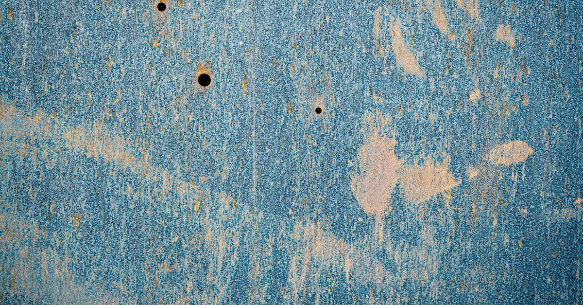 Textured backdrop of aged rusty metal wall with scratches and stains on blue surface
