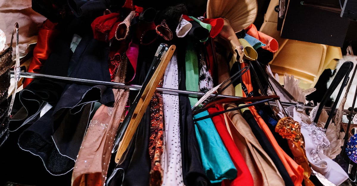 An array of vibrant and glamorous costumes displayed on hangers in an indoor setting.