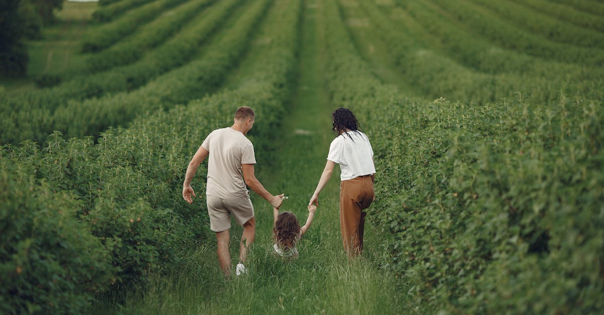 Happy family walking together through a lush green field enjoying nature and togetherness.