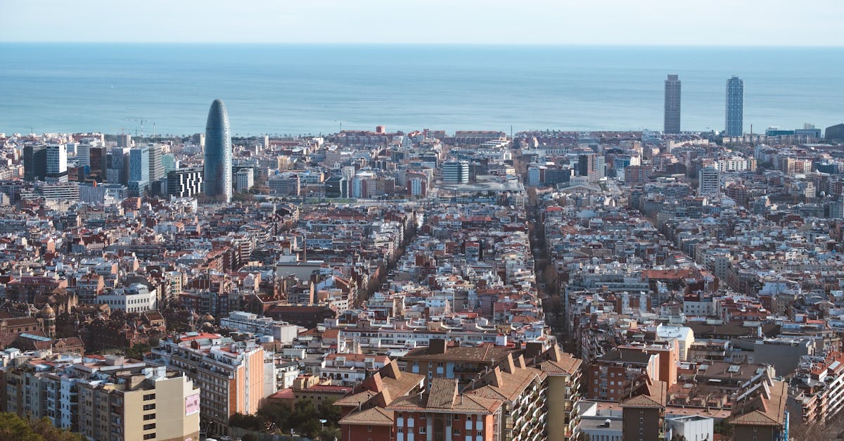 Panoramic aerial shot of Barcelona's cityscape, showcasing the Mediterranean Sea and iconic architecture.