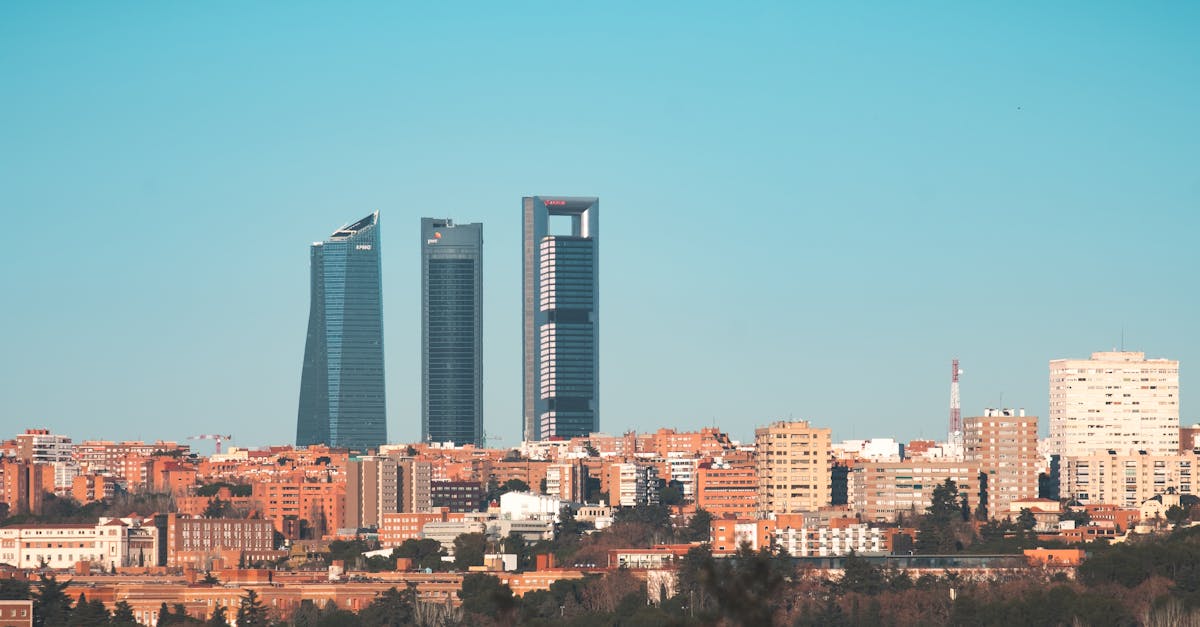 Skyline view of the Cuatro Torres Business Area with a clear blue sky backdrop in Madrid, Spain.