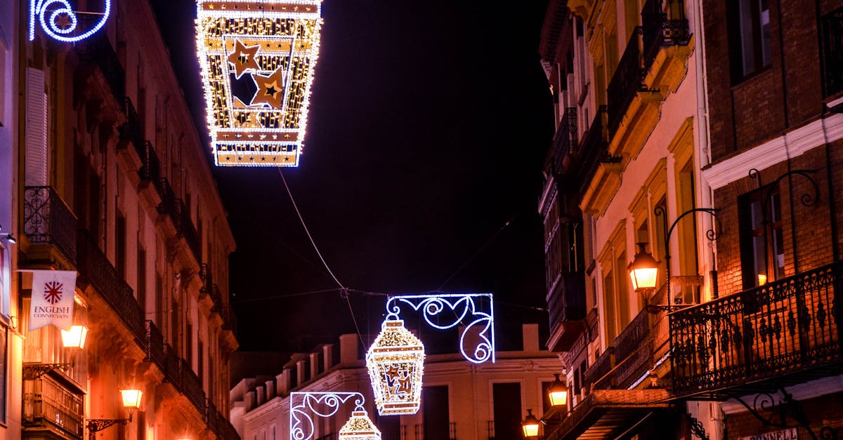 Vibrant street lanterns illuminate a historic street in Seville, creating an enchanting evening atmosphere.