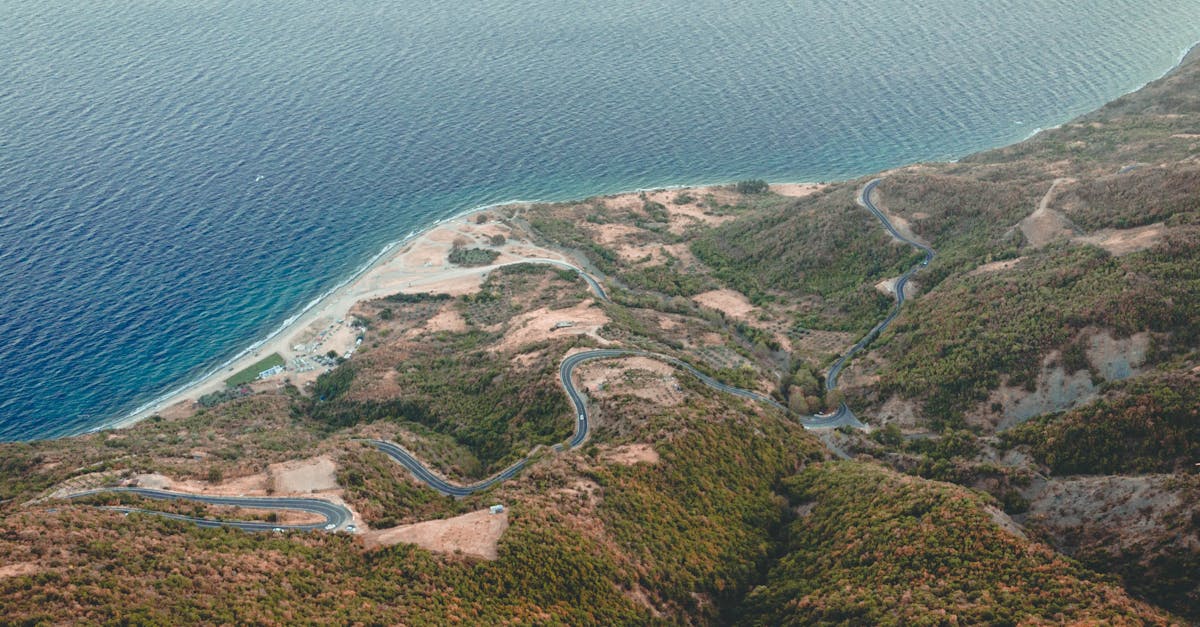 Stunning aerial shot of a winding highway along rugged seaside hills.
