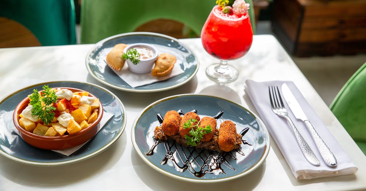 A vibrant spread of Spanish tapas dishes paired with a refreshing cocktail on a sunlit table.