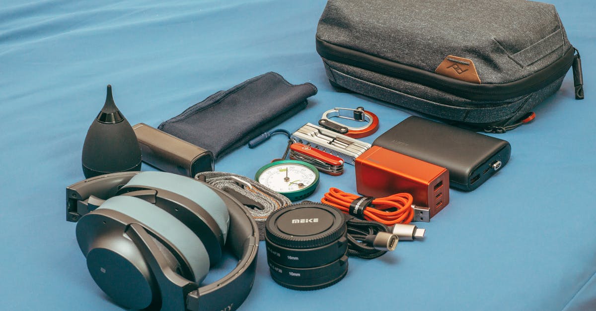 Flat lay of travel gear including headphones, a compass, power bank, and accessories.