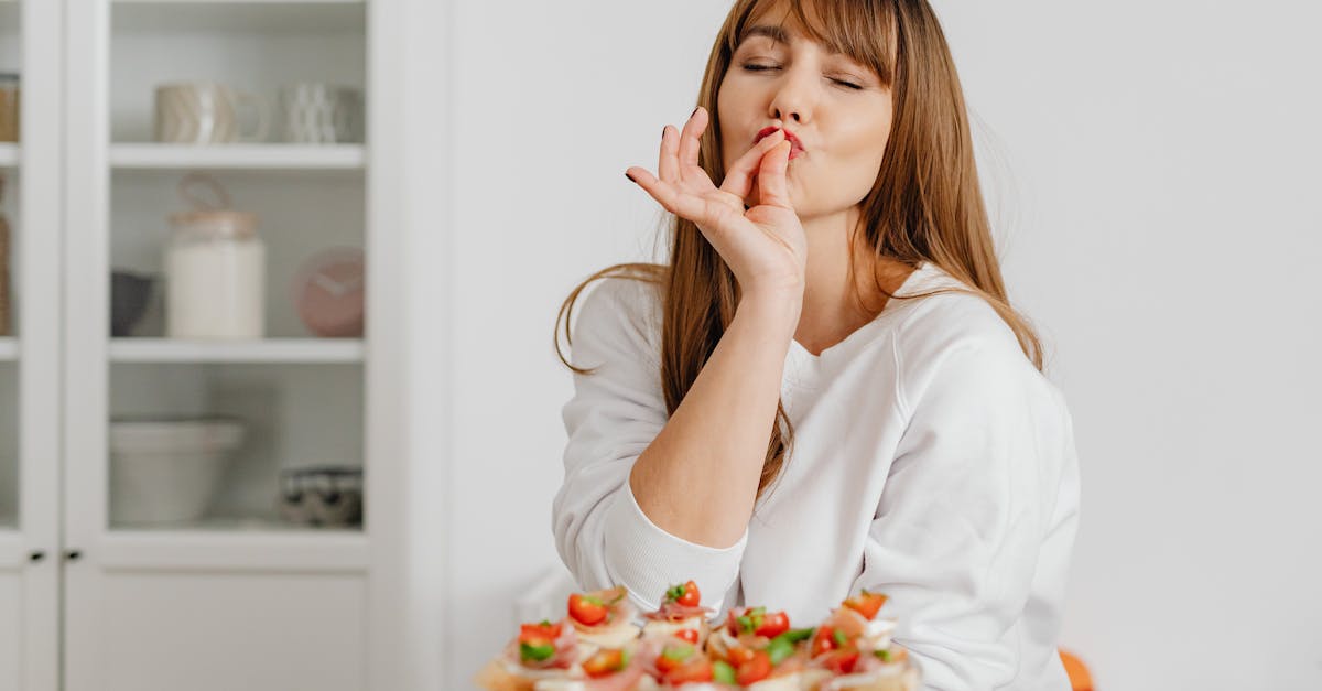 Woman savoring delicious bite-sized treats in a modern kitchen setting.