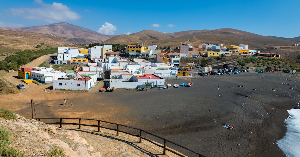 Scenic view of Ajuy village surrounded by hills and a distinctive black sand beach.
