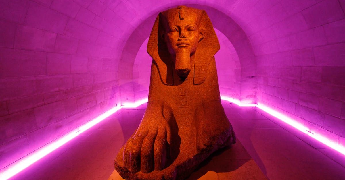 Captivating image of an Egyptian sphinx sculpture illuminated by ambient purple lighting in a tunnel.