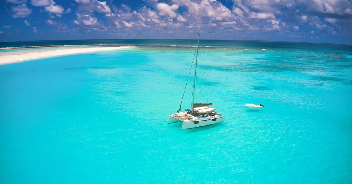 A scenic aerial shot of a sailboat and a sandbar in the turquoise waters of Mauritius.