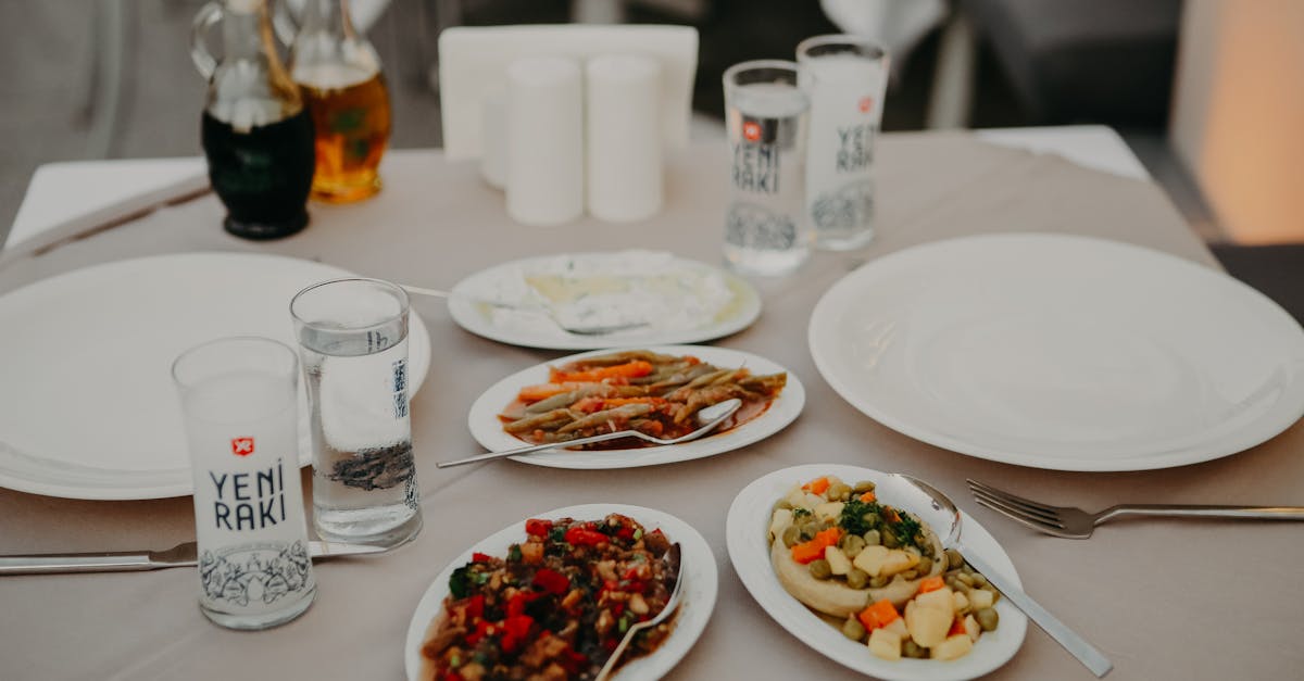 From above of served table with assorted delicious appetizers with beverages and dishware on veranda of restaurant in evening