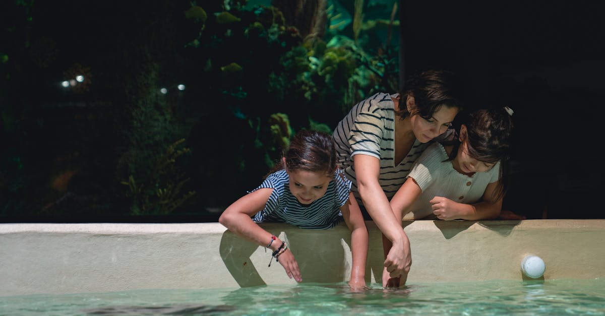Mother and daughters engage with marine life at an aquarium exhibit, enjoying quality time together.