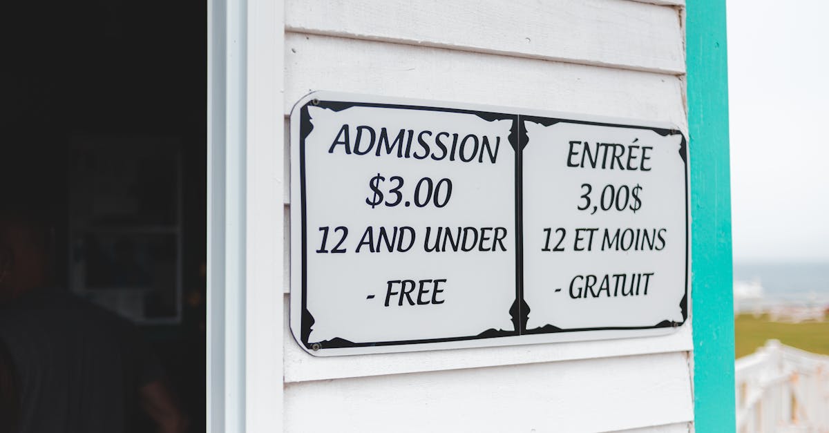 Bilingual sign displaying admission prices in English and French at building entrance.